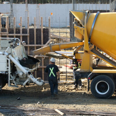 Ready To Pour Cement truck ready to pour concrete into a boom trucks hopper.