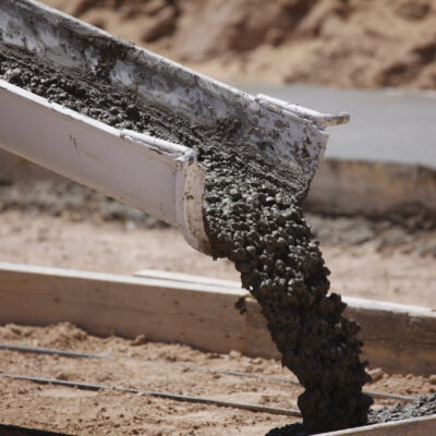 Cement Pouring from a Mixer Truck Chute Cement pouring from a mixer truck chute. Some motion blur on the cement.