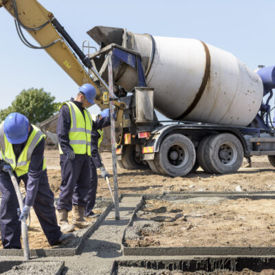 Apprentice builders laying concrete foundations on building site Apprentice builders laying concrete foundations on building site
