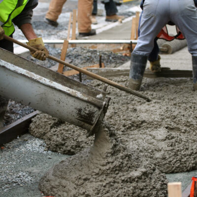 Construction workers working on the sidewalk Construction workers pour and smooth concrete on a sidewalk renewal project.